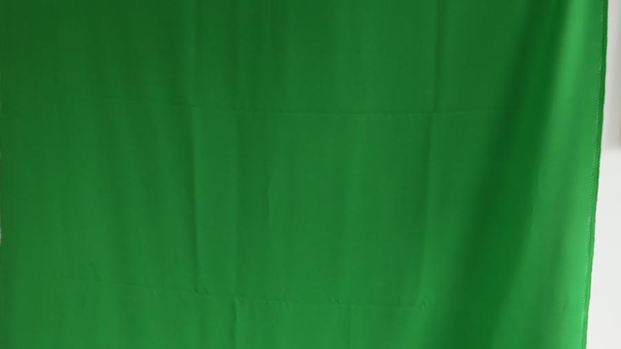 Grüner Stoff wird als Greenscreen-Hintergrund verwendet und wirft leichte Falten.
